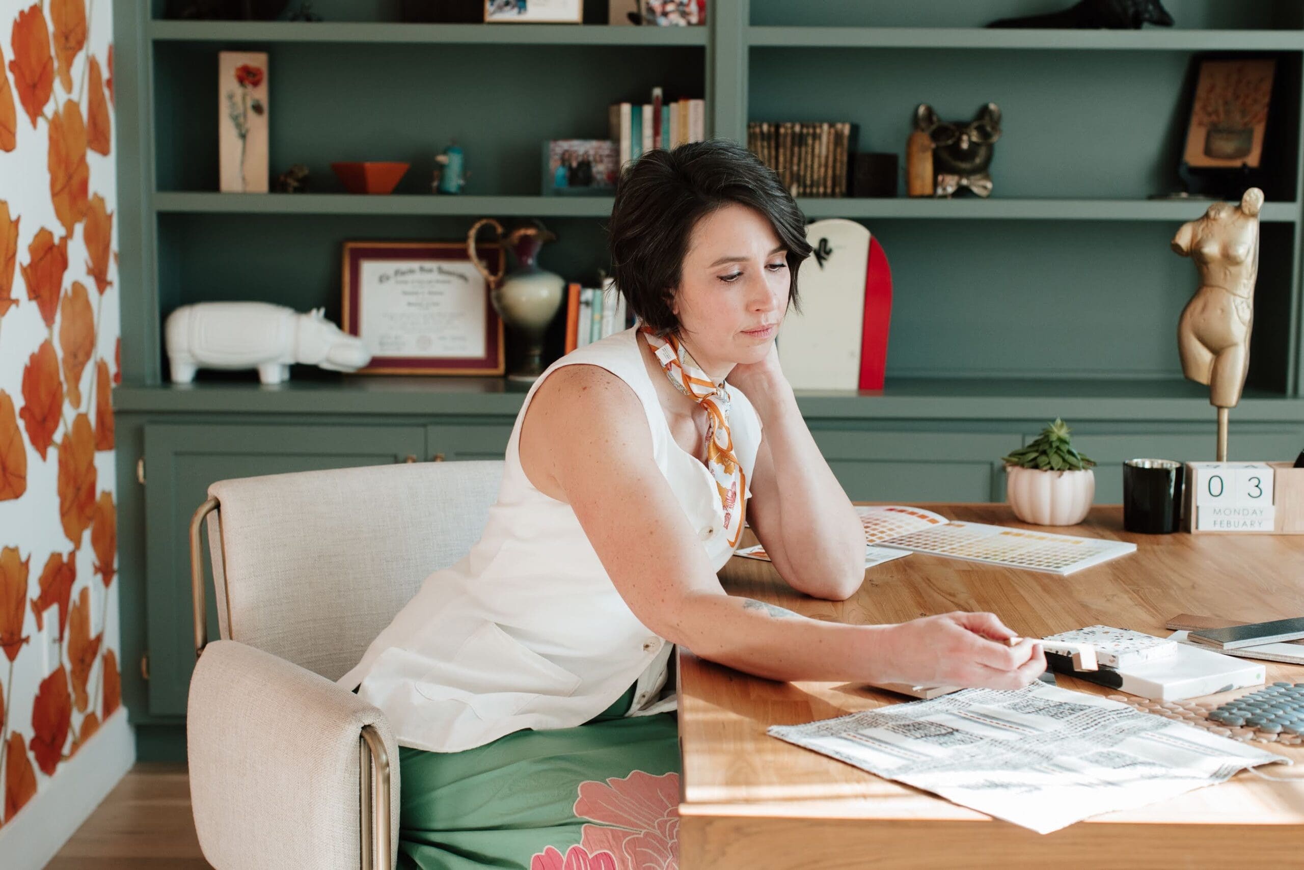 Designer sitting at desk with design documents and finishes