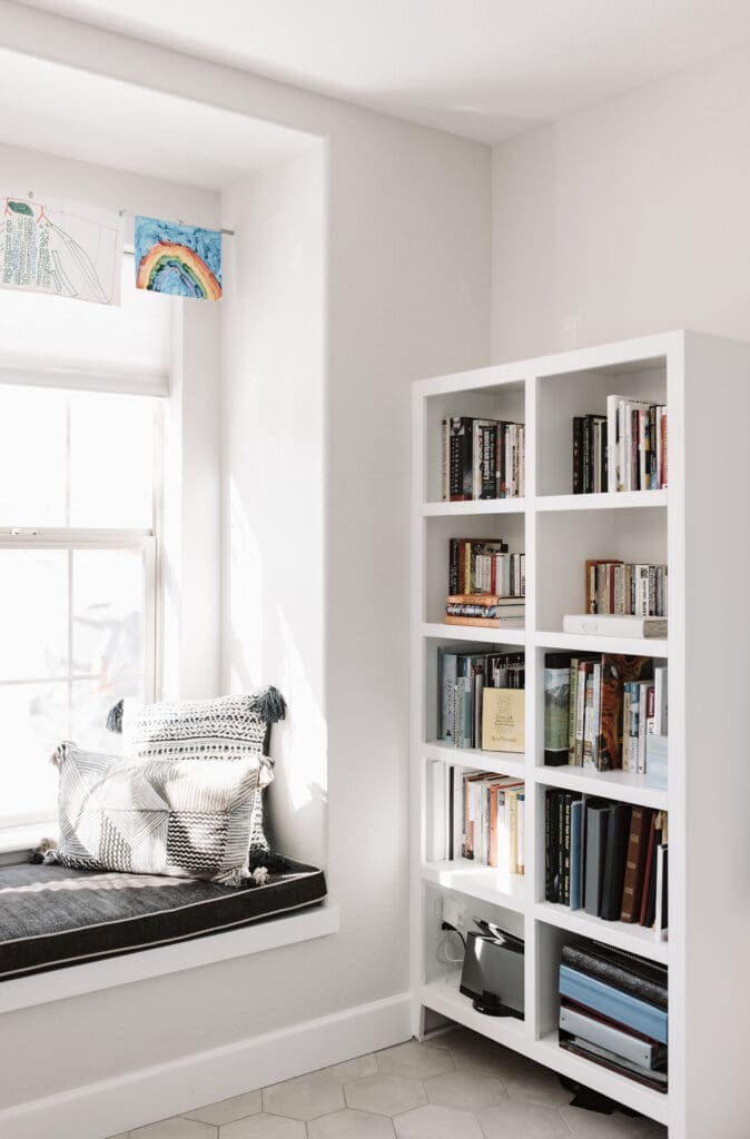 Built-in bookshelf with custom black Kravet window seat and colorful, textural Loloi pillows